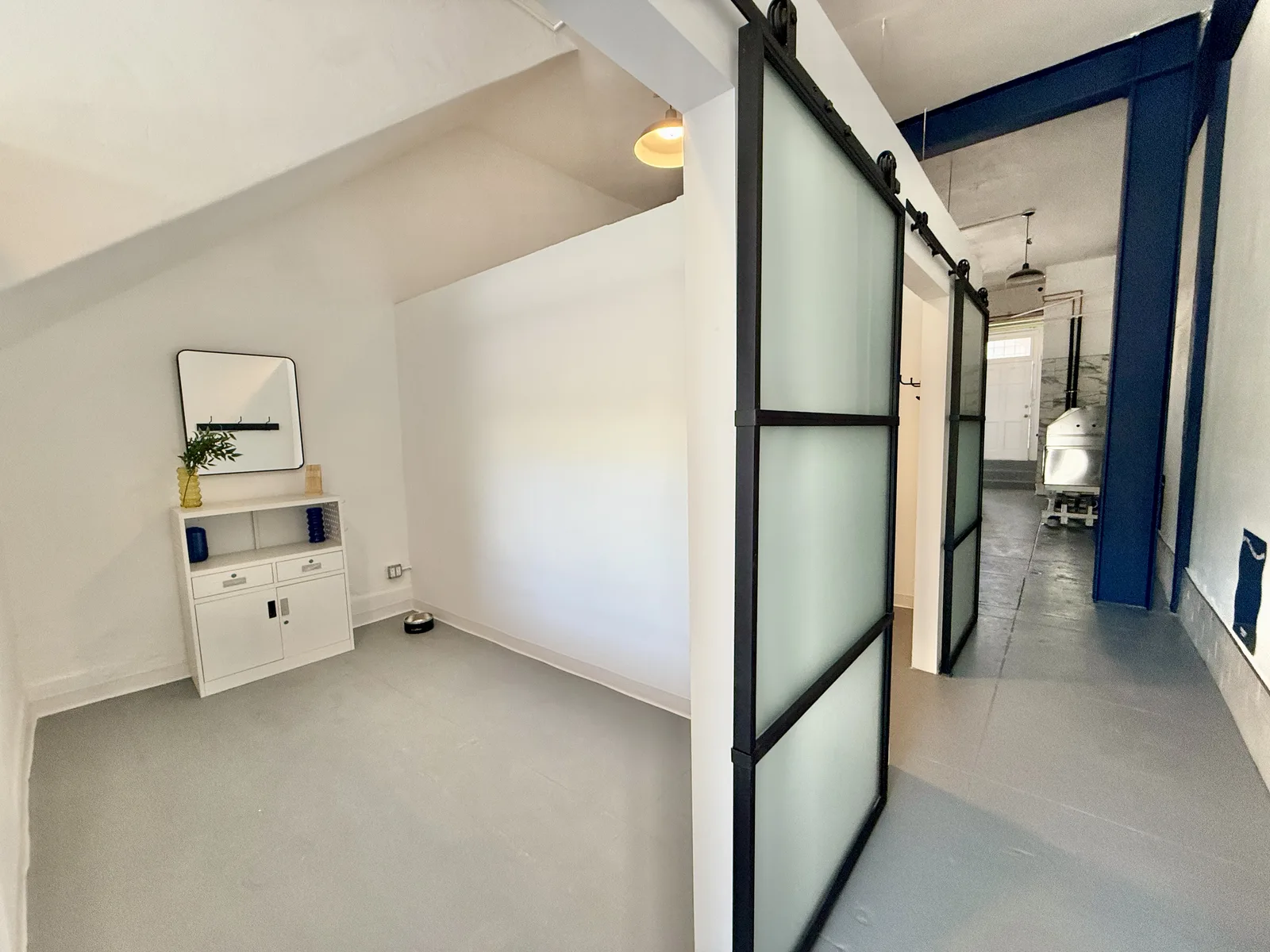 A bright, move-in-ready Snout Studios suite with a frosted sliding door